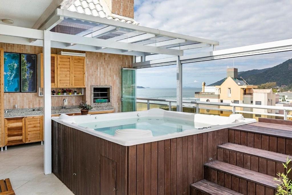 uma banheira de hidromassagem numa cozinha com vista para o oceano em Duplex vista para o mar na praia dos Açores em Florianópolis