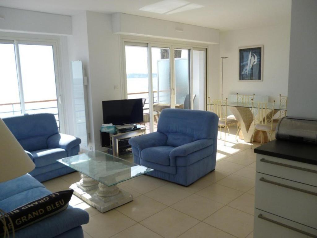 uma sala de estar com duas cadeiras azuis e uma mesa em Appartement La Baule, 3 pièces, 4 personnes - FR-1-245-113 em La Baule