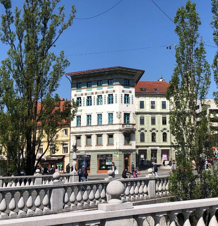 a white building with a fence in front of it at Triple Bridge Ljubljana in Ljubljana