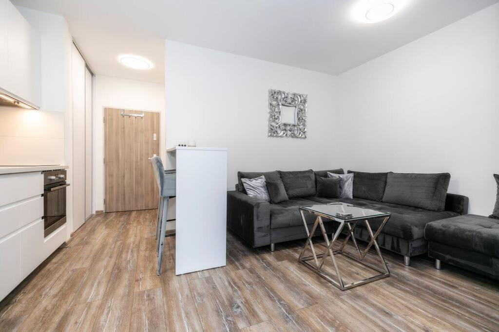 ein Wohnzimmer mit Sofa und Tisch in der Unterkunft ALURE RESIDENCES 1 & 24h self check-in, free parking in front of the apartment building, new building, terrace, cafe with breakfast in the apartment building, next to the aqua park in Banská Bystrica