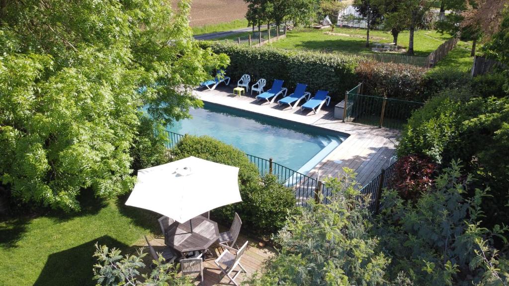 an overhead view of a pool with an umbrella and chairs at Chambres d'hôtes les Hautes Papinières in Saint-Prouant