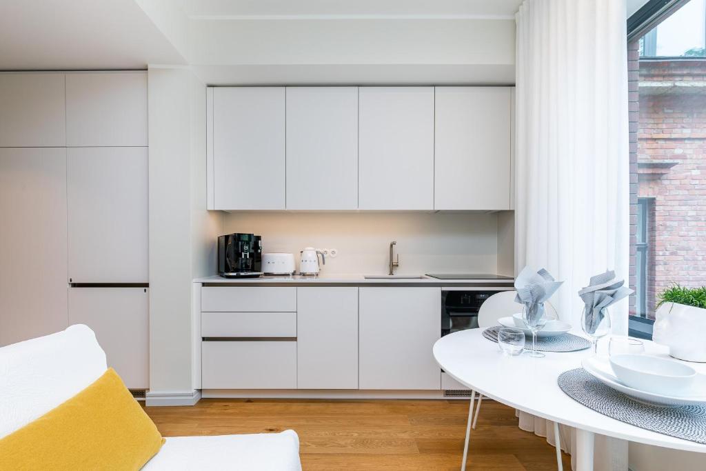 een keuken met witte kasten en een witte tafel bij Vallikraavi Cozy Apartment in Tartu