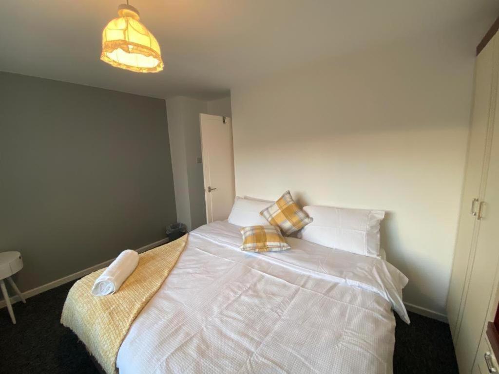 a bedroom with a large white bed with two pillows at Spacious Luxurious Serviced Accommodation 3 in Warmsworth