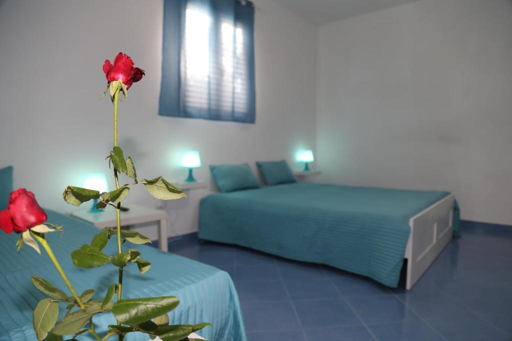 1 dormitorio con 2 camas y una flor en el primer plano en Un Tuffo alla Scala dei Turchi, en Realmonte