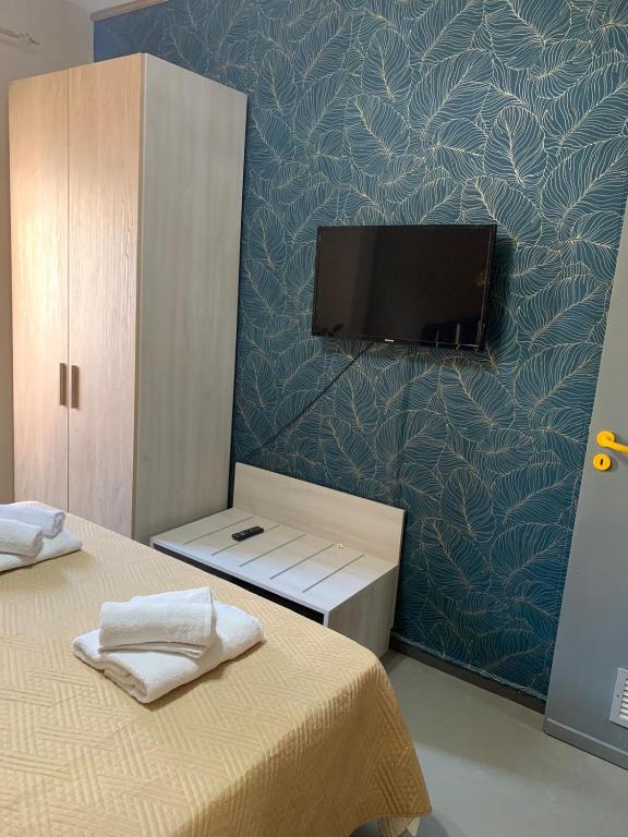 una camera con TV a parete e un letto di lacasettadinoel a Lampedusa