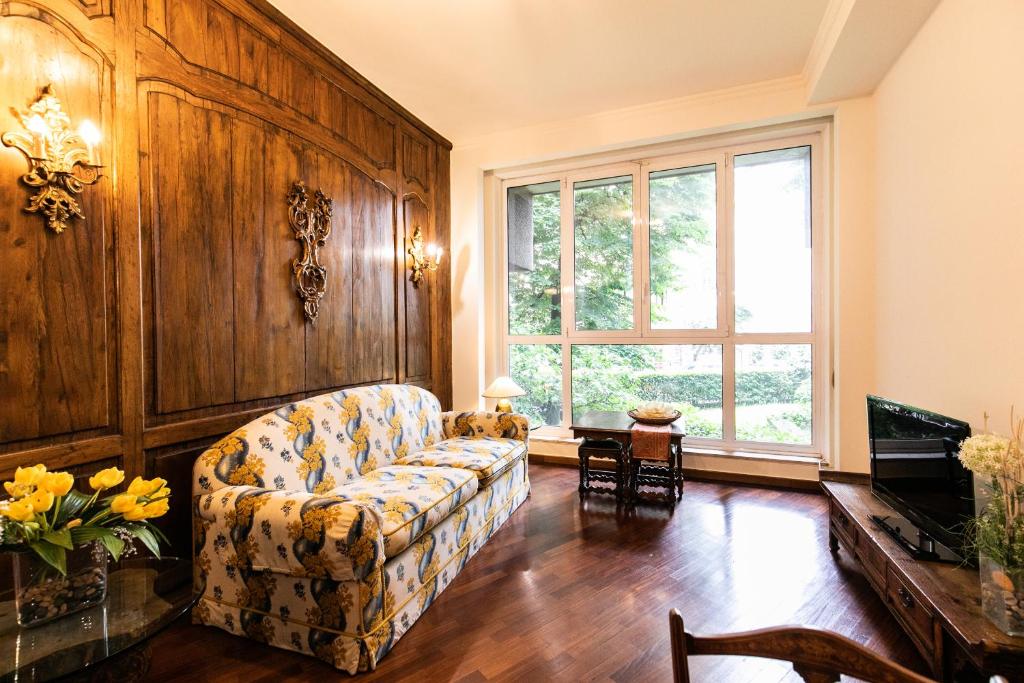 Klimt - Jacuzzi 5 Star - Luxury Design Apartment في ميلانو: غرفة معيشة مع أريكة ونافذة كبيرة