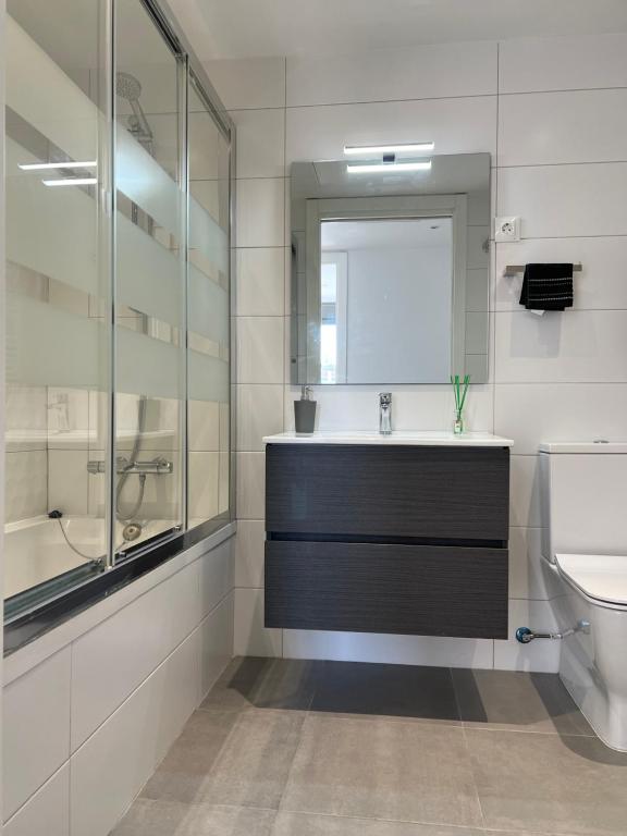a bathroom with a sink and a toilet and a mirror at Habitación confortable para parejas (1) in Barcelona