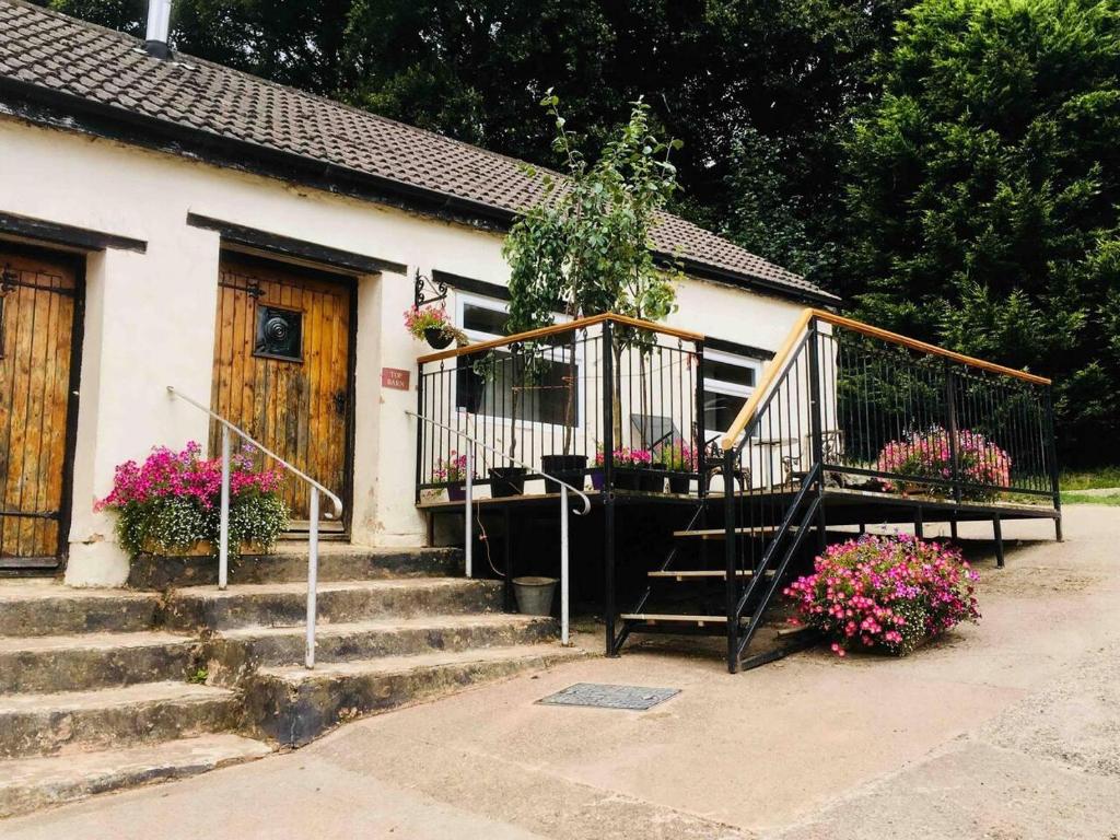 una casa con scale e fiori davanti di Cosy 3-Bed Apartment on Exmoor a Minehead