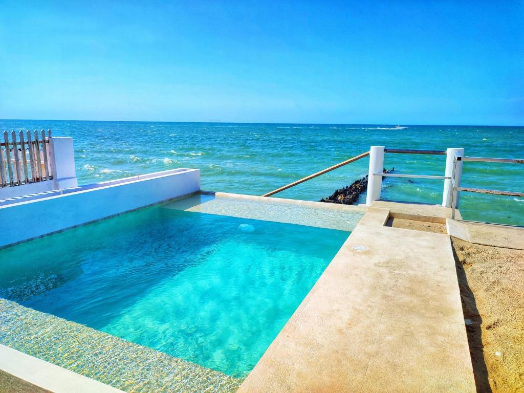 a swimming pool with the ocean in the background at Casa Chelem in Chelem