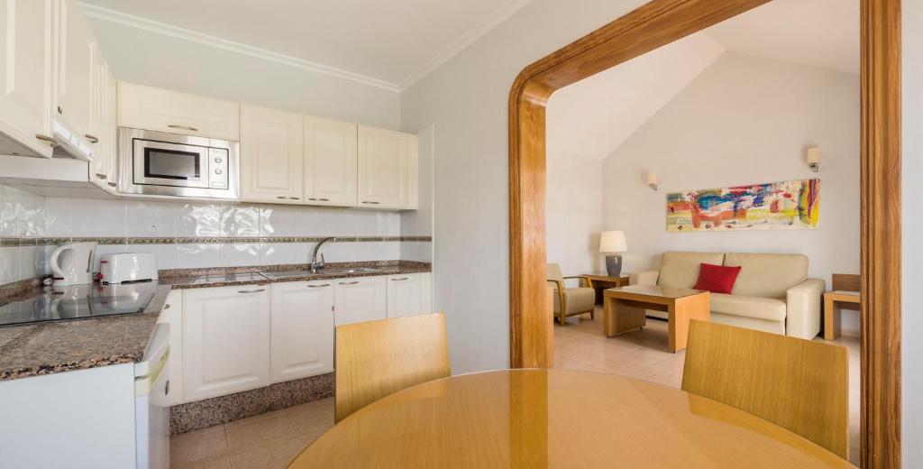 a kitchen and living room with a table in a room at ILUNION Costa Sal Lanzarote in Puerto del Carmen