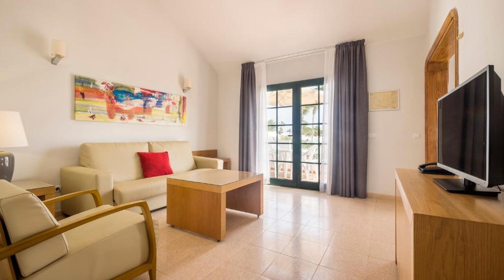 a living room with a couch and a tv at ILUNION Costa Sal Lanzarote in Puerto del Carmen