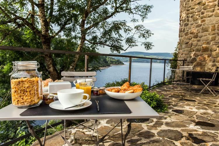 einen Tisch mit einer Schüssel Essen und einer Tasse Kaffee in der Unterkunft Chateau De Val in Lanobre