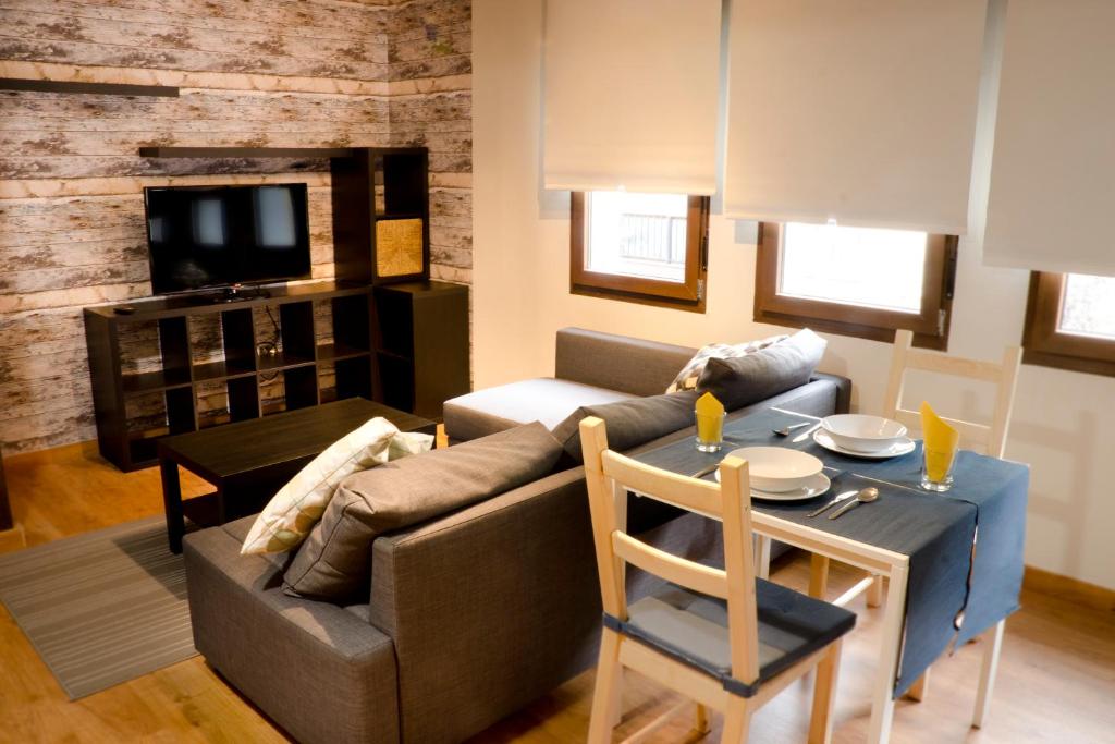 - un salon avec un canapé et une table dans l'établissement Loft Pelayo Apart II, à Arriondas