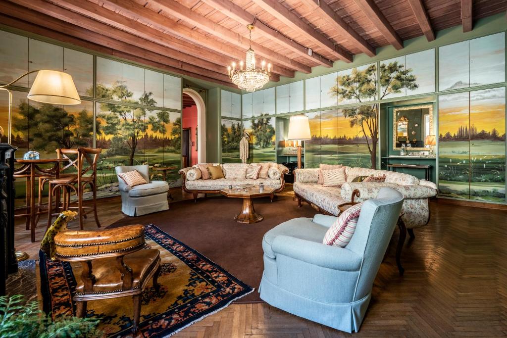 FORESTERIA di PALAZZO RADICI في بيرغامو: غرفة معيشة مع أريكة وكراسي وطاولة