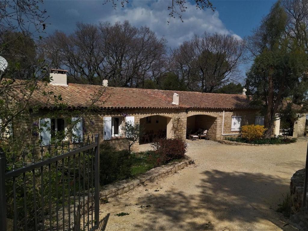 a brick house with a fence in front of it at La maison d'en haut in La Capelle-et-Masmolène