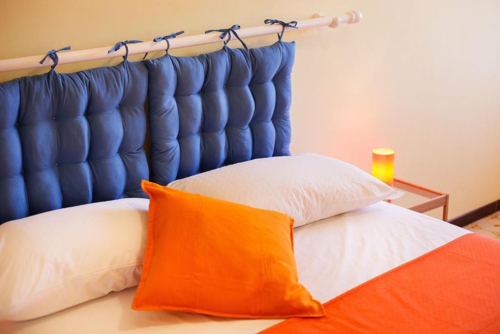 a bed with a blue headboard and an orange pillow at B&B Sorrento Sunshine in Sorrento