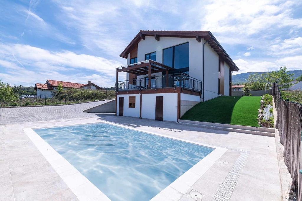 a house with a swimming pool in front of a house at Villa Vacacional La Raizona in Pancar