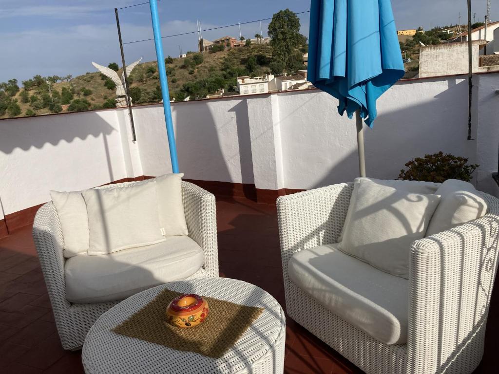 two chairs and a table and an umbrella on a balcony at Casa Linda in Guaro