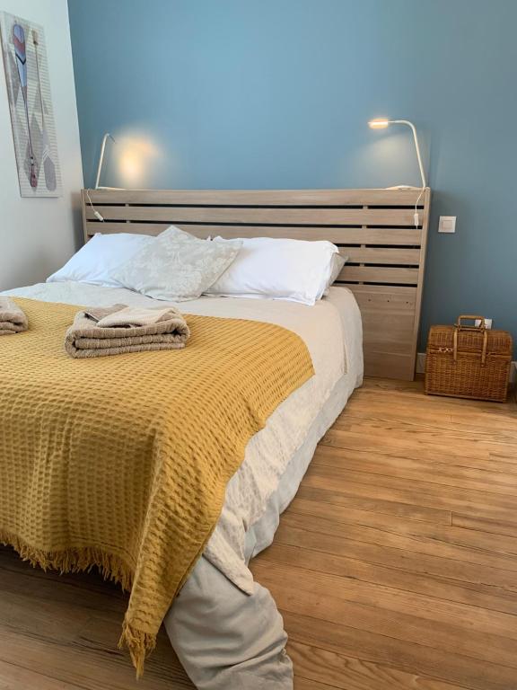 um quarto com uma cama com um cobertor amarelo em Chez Viviane em Fontaine-Étoupefour