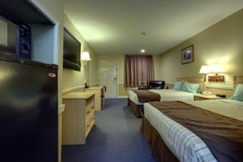 a hotel room with two beds and a television at Edinburg Executive Inn in Edinburg