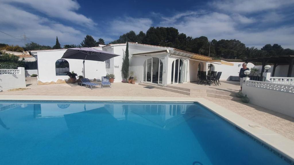 una villa con piscina di fronte a una casa di Cheerful 2-bedroom villa with private pool a Calpe
