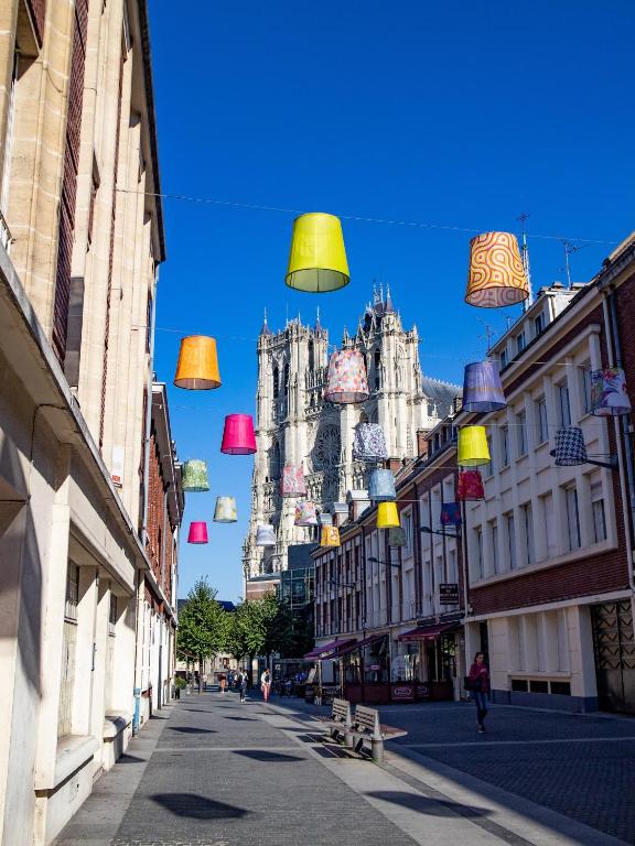 a city street with colorful lights hanging from buildings at Appartement Prestige - Amiens in Amiens
