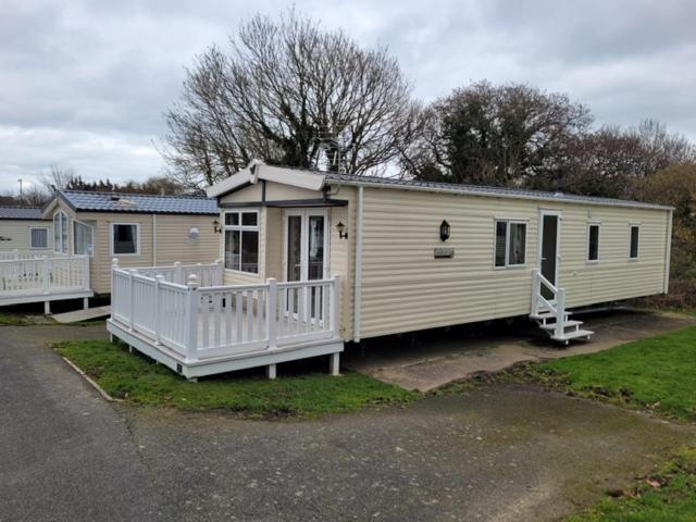 a mobile home with a porch and a house at Roslyn at Lower Hyde Park, Isle of Wight in Shanklin