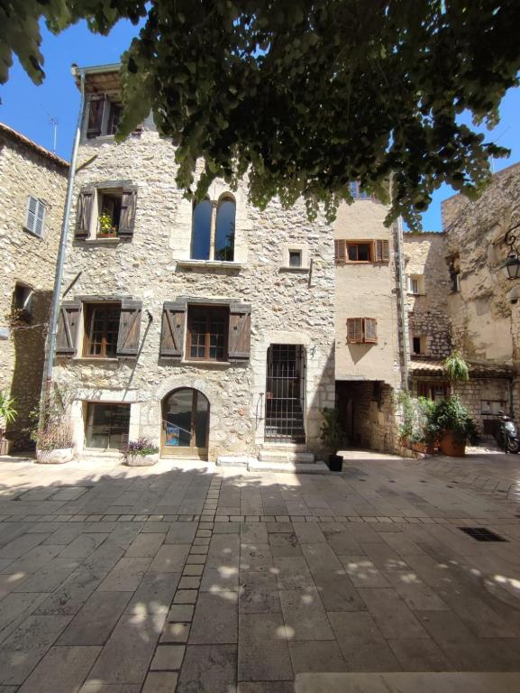 un antiguo edificio de piedra en un patio en Chambre d'hôtes Les Tomettes en Vence