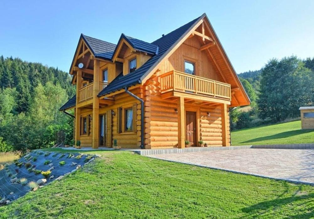 a log cabin with a gambrel roof at Miodowa Chata in Brenna