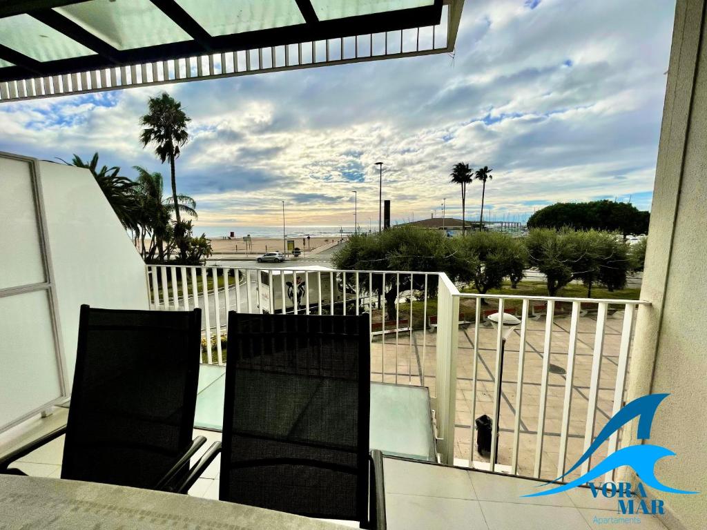 een balkon met 2 stoelen en uitzicht op het strand bij Apartaments Voramar 2 in Cambrils