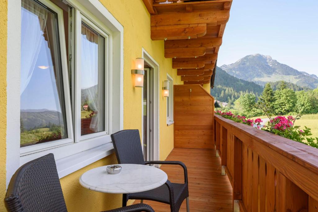 a porch with a table and chairs on a balcony at Gasthof Waldwirt in Russbach am Pass Gschütt