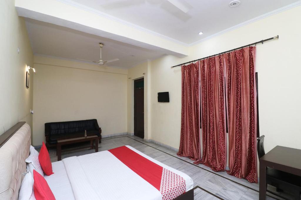 a bedroom with a bed and a desk and a window at OYO Hotel Ayaan in Bareilly