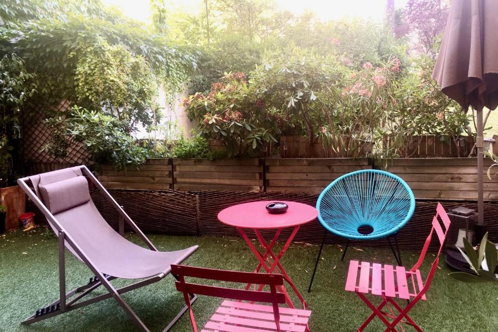 un groupe de chaises et une table et un ventilateur bleu dans l'établissement Apartment with garden near Montmartre, à Paris