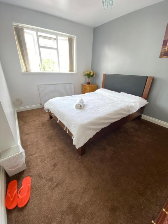 Un dormitorio con una cama grande con zapatos rojos. en budget private rooms close to city centre and airport, en Birmingham