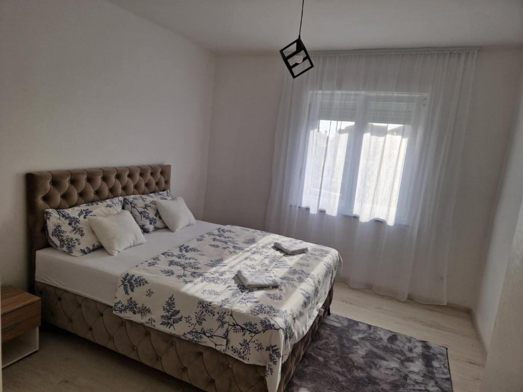 - une chambre avec un grand lit et une fenêtre dans l'établissement Apartman Platan, à Trebinje