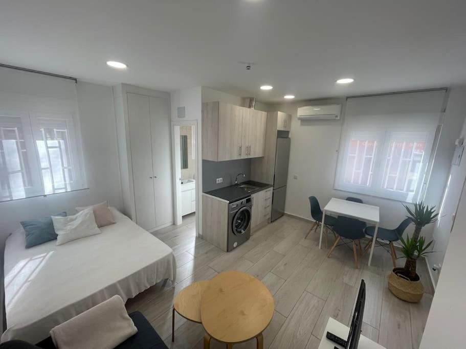 um quarto com uma cama, uma mesa e uma cozinha em Central studio with parking space-AFRIC em Madrid