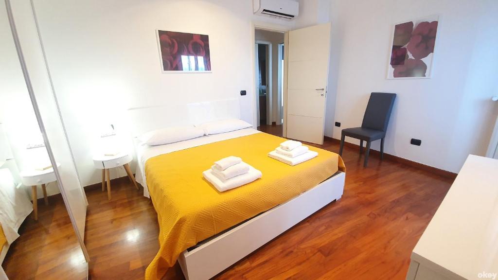 una camera da letto con un letto e due asciugamani di Wow Waterfront Apartment - Bari Fesca a Bari