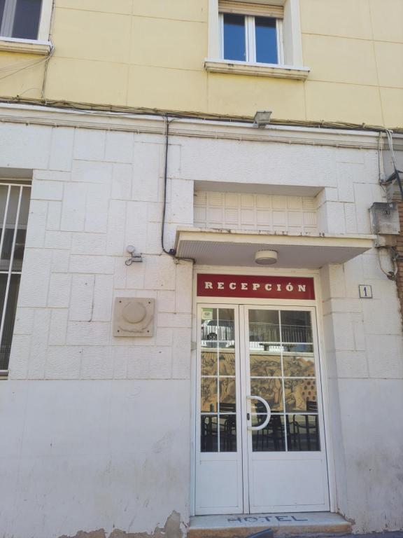 un edificio con una puerta blanca y una señal en él en Hostel Pilgrim's, en Navarrete