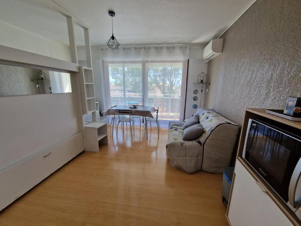 a living room with a couch and a table at Studio cabine Canet Plage Parking in Canet-en-Roussillon