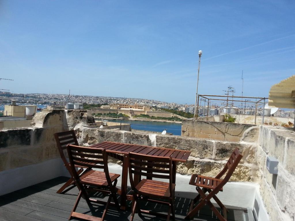een houten tafel en 2 stoelen op een balkon bij Valletta Maisonette Malta in Valletta