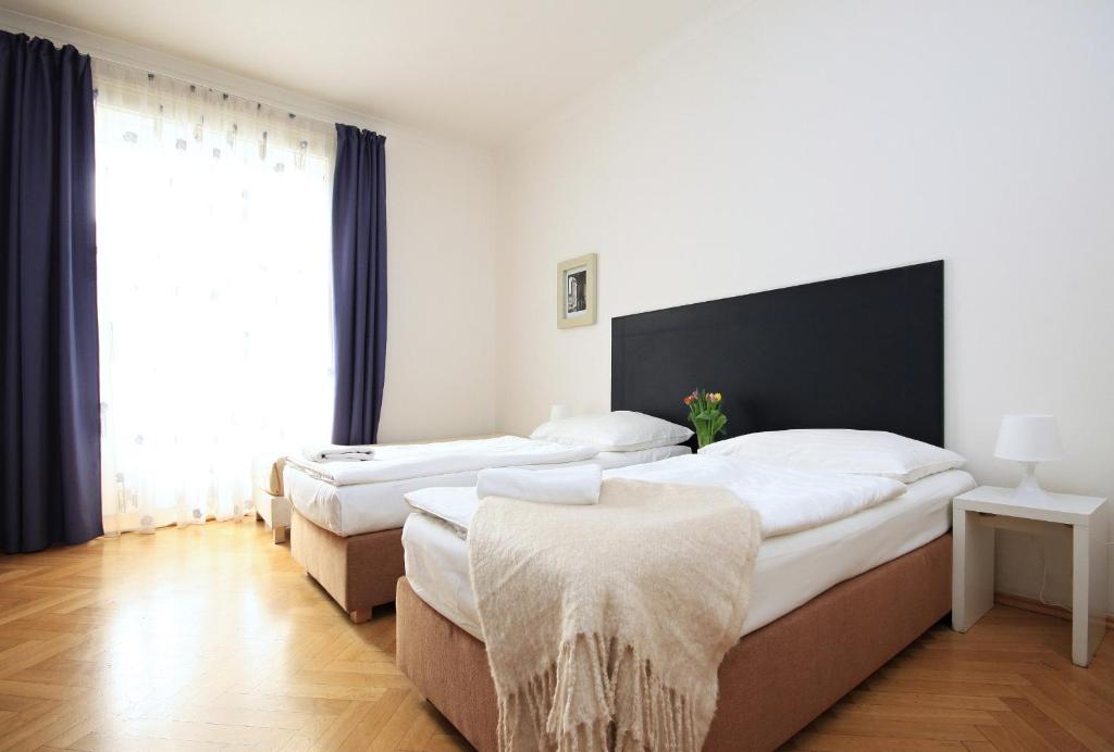 1 Schlafzimmer mit 2 Betten und einem großen Fenster in der Unterkunft Quadrio Bedroom Central Apartment in Prag