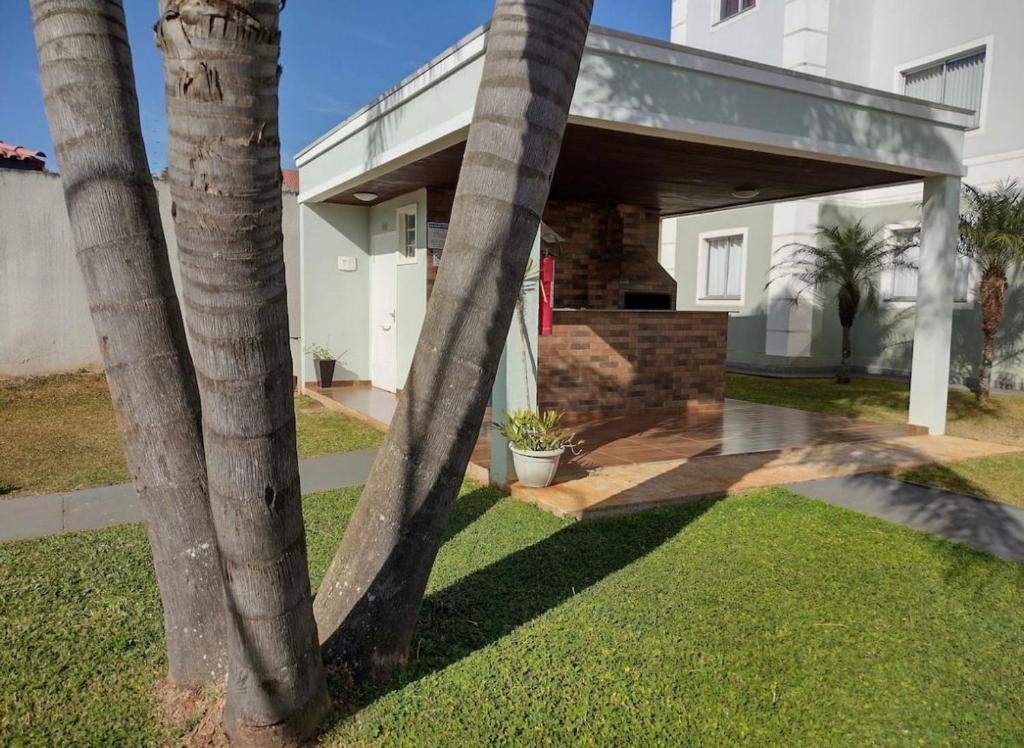 una casa con dos palmeras en el patio en Apartamento novo wi-fi + TV, en Ponta Grossa