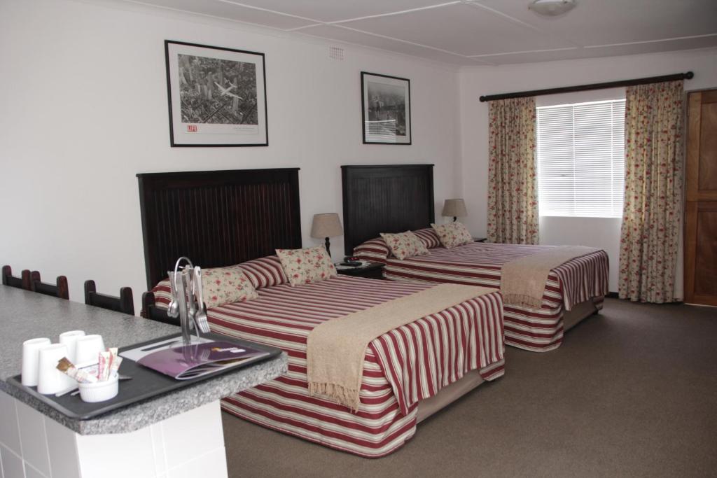 a hotel room with two beds and a counter at Laings Lodge in Laingsburg