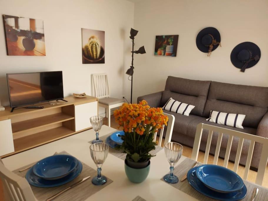 una sala de estar con una mesa con flores y platos azules en Puerta Del Sol Casa Ilaria, en Caleta de Fuste