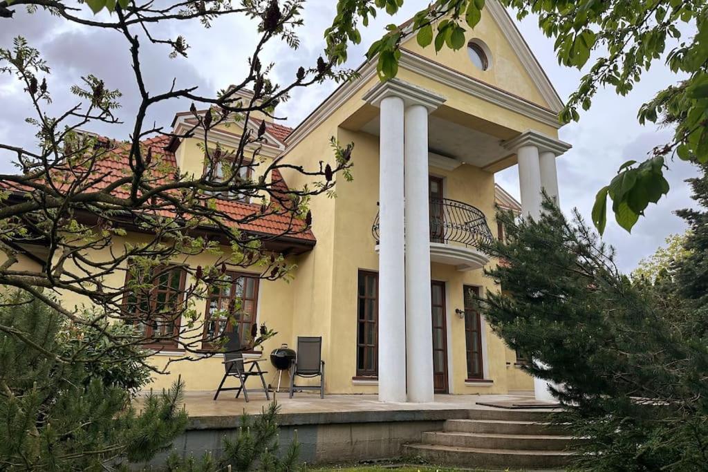a large yellow house with a porch and columns at Dako Mansion, Stylish, Modern, Cosy in Rzeszów