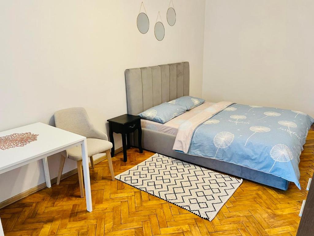 1 dormitorio con 1 cama, 1 mesa y 1 silla en Джерельна 25, апартаменти в центрі з двома ізольованими спальнями, en Leópolis