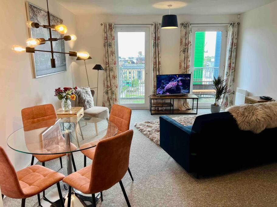 un soggiorno con tavolo e sedie in vetro di Home2home Serviced Apartment a Cambridge