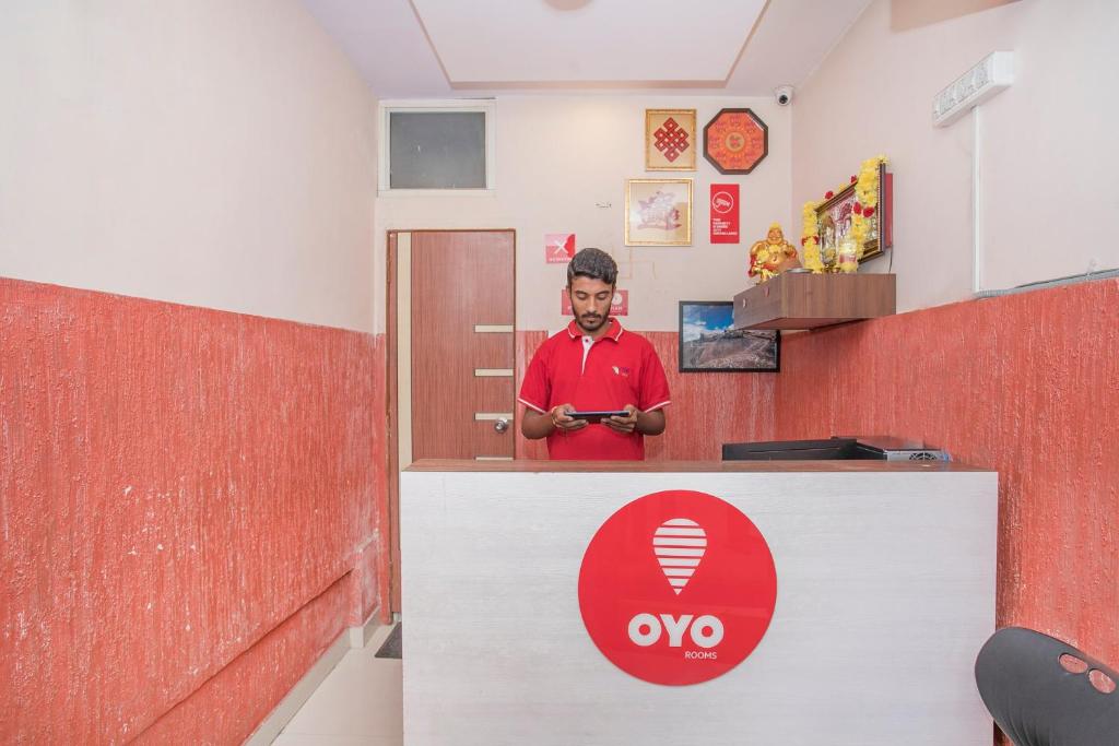 a man standing behind a counter in a room at OYO 8116 Park Inn in Bangalore