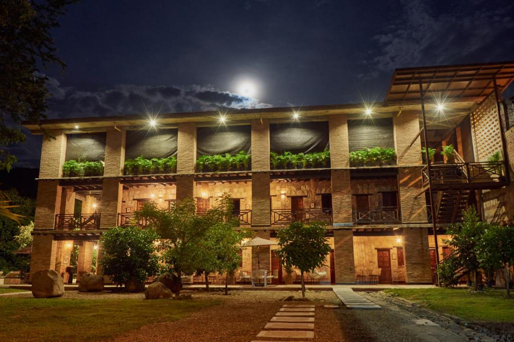 um edifício com plantas de lado à noite em Mentto Hotel em Guaduas