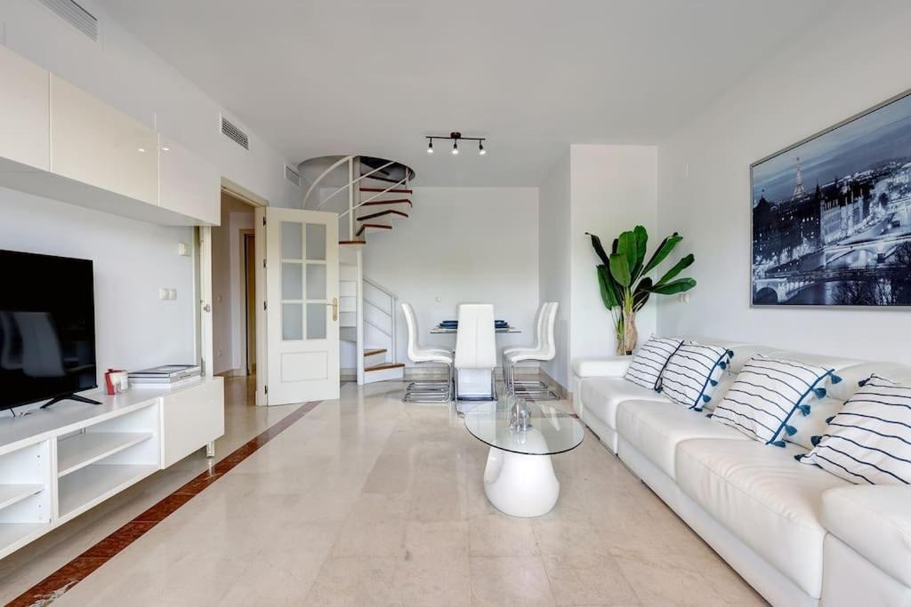 sala de estar blanca con sofá blanco y TV en Stunning Duplex 5 minutes from Puerto Banús, en Marbella